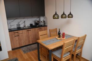 a kitchen with a wooden table with chairs and a sink at Zlatni Javor Twins in Jahorina +18 photos