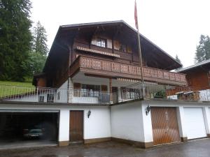 ein großes Holzhaus mit Balkon in der Unterkunft Alpenrösli in Schwarzsee