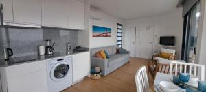 a kitchen and a living room with a washing machine at Calheta Nest in Calheta