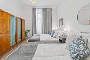 ein Hotelzimmer mit zwei Betten und einer Couch in der Unterkunft Spacious 2 Bedroom I 2 Minutes to Metro and Train Station in Wien