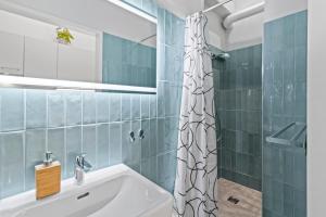 ein Badezimmer mit Duschvorhang und Waschbecken in der Unterkunft Spacious 2 Bedroom I 2 Minutes to Metro and Train Station in Wien