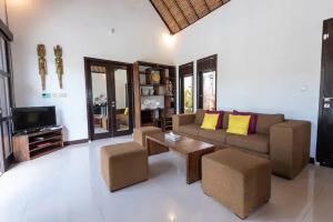 ein Wohnzimmer mit Sofa und Fernseher in der Unterkunft Villa Amber in Uluwatu