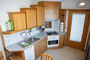 a kitchen with wooden cabinets and a sink at Ferienwohnung Nussbaumblick in Ottensheim