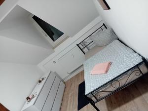 a small bedroom with a bed with a pink pillow at Stellas Monteurwohnungen in Crimmitschau