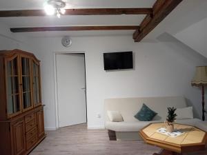 a living room with a white couch and a table at Stellas Monteurwohnungen in Crimmitschau