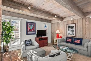 un soggiorno con divani e TV a schermo piatto di Chateau Eau Claire Unit 1, Stylish Condo Overlooking the River, Walking Distance to Downtown ad Aspen