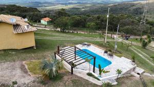 an overhead view of a swimming pool in a house at Chalés Vila Real - Tranquilidade na Serra de Carrancas - Piscina com uma vista espetacular do Pôr do Sol in Carrancas