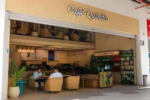 two men sitting at a table outside of a cafe umbrella at Cerritos Premium Tower & Mall in Pereira