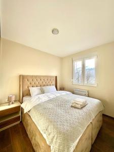 a bedroom with a large bed and a window at Pine forest view apartment in Kolašin