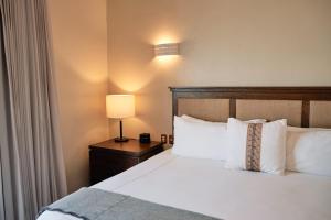 a hotel room with a bed with a lamp and pillows at Casa Lucila Mazatlán Curamoria Collection in Mazatlán