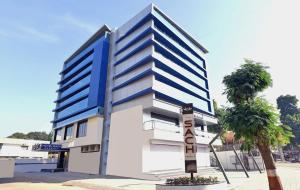 een blauw-wit gebouw met een palmboom ervoor bij Hotel Sach Regency in Anand