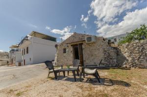 Pagliaio Tipico nello Junno في ماتيناتا: طاولة وكراسي أمام المبنى