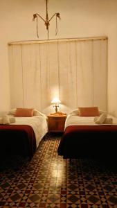 a room with two beds and a table with a lamp at Entre el mar y la montaña in Jijona