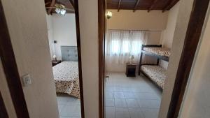 a small room with two beds and a window at Lomitas Villa Gesell in Villa Gesell +6 photos