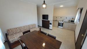 a living room with a dining table and a kitchen at Lomitas Villa Gesell in Villa Gesell