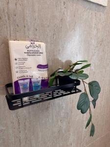 een plank met een doos en een plant aan de muur bij غرفة على الطراز الريفي in Riyad