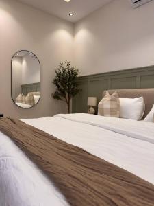 een slaapkamer met een groot wit bed met een spiegel bij غرفة على الطراز الريفي in Riyad