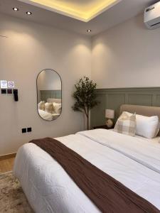een slaapkamer met een groot bed en een spiegel bij غرفة على الطراز الريفي in Riyad