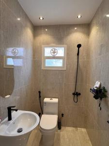 een badkamer met een wit toilet en een wastafel bij غرفة على الطراز الريفي in Riyad +8 foto's