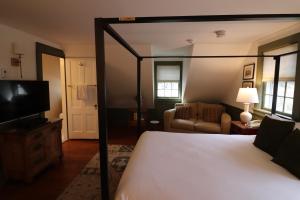 a bedroom with a canopy bed and a living room at Swift House Inn in Middlebury