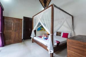 a bedroom with a bed with a canopy at Villa Amber in Uluwatu