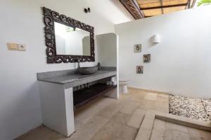 a bathroom with a sink and a mirror on the wall at Villa Amber in Uluwatu