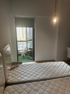 a bed in a room with a large window at TWIN BED-ROOM Sadaf Community near TRAM in Dubai