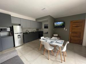 a kitchen with a table and chairs and a refrigerator at Elite Mendoza Park in La Cieneguita