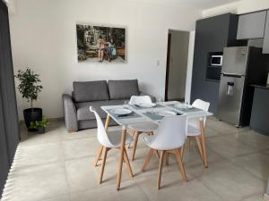a living room with a white table and white chairs at Elite Mendoza Park in La Cieneguita +2 photos