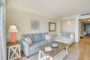 a living room with a blue couch and a table at 1 Mi to Myrtle Beach Boardwalk Oceanfront Condo in Myrtle Beach +22 photos