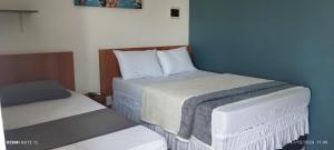 a small room with two beds and a bedskirts at Pousada Santo Rio in Piranhas
