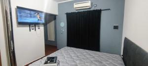 a room with a bed and a tv on the wall at Casa de Fin de semana in María Grande