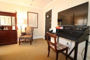 a room with a black desk with a chair and a dresser at Swift House Inn in Middlebury