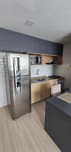 una cucina con frigorifero in acciaio inox e mobili in legno di Apartamento no Edifício Manhattan - Bairro Nobre de Caruaru a Caruaru Altre 25 foto