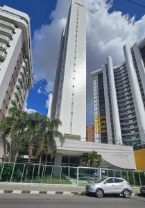 a car parked in front of two tall buildings at Apartamento no Edifício Manhattan - Bairro Nobre de Caruaru in Caruaru