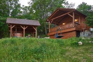 a large wooden cabin with a gazebo at Kisleshegy Vászoly Vendégház in Dörgicse