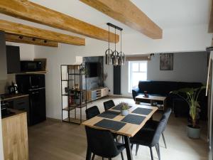 a living room with a table and chairs and a kitchen at Apartamenty Rynek Szamotuły in Szamotuły +10 photos