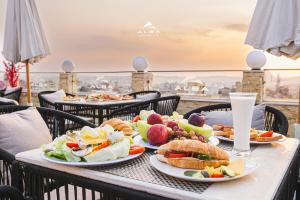 uma mesa com pratos de comida numa varanda em Alba pyramids view em Cairo