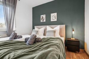 ザンクト・ヴェンデルにあるWendel Living I - Gemütlich und modernの緑の壁と大きなベッドのある寝室