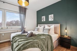ザンクト・ヴェンデルにあるWendel Living I - Gemütlich und modernの緑の壁と大きなベッドのある寝室