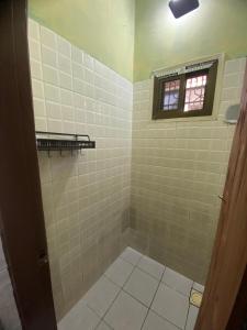 a bathroom with a tiled shower with a window at Serenity Homestay in Dar es Salaam