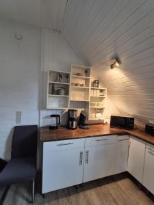 a kitchen with white cabinets and a wooden counter top at Ferienwohnung am Kreisel in Duderstadt