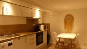 una piccola cucina con lavello e microonde di CosyRouen Jacuzzi Parking gratuit a Rouen
