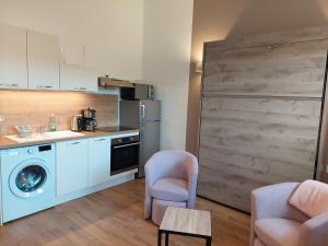 a kitchen with a washing machine and a washer at La Ferme du BoisDieu in Avallon