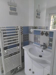 a white bathroom with a sink and a shower at Les nids de la Baie in Favières