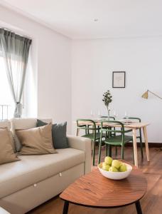 un salon avec un canapé et une table dans l'établissement Luminosos apartamentos con ascensor en el Centro, SOL, à Madrid