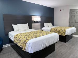 a hotel room with two beds in a room at Baymont by Wyndham Grenada in Grenada