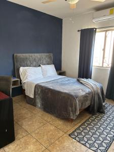 een slaapkamer met een bed met een blauwe muur bij Habitacion Arboleda in Saltillo