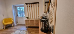 salon z żółtym krzesłem i schodami w obiekcie Gîte 4 personnes avec piscine et bain nordique proche des plages du débarquement w mieście Le Manoir