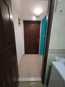ein Bad mit brauner Tür und Fliesenboden in der Unterkunft Casa Mia 2 Porto in Herceg-Novi